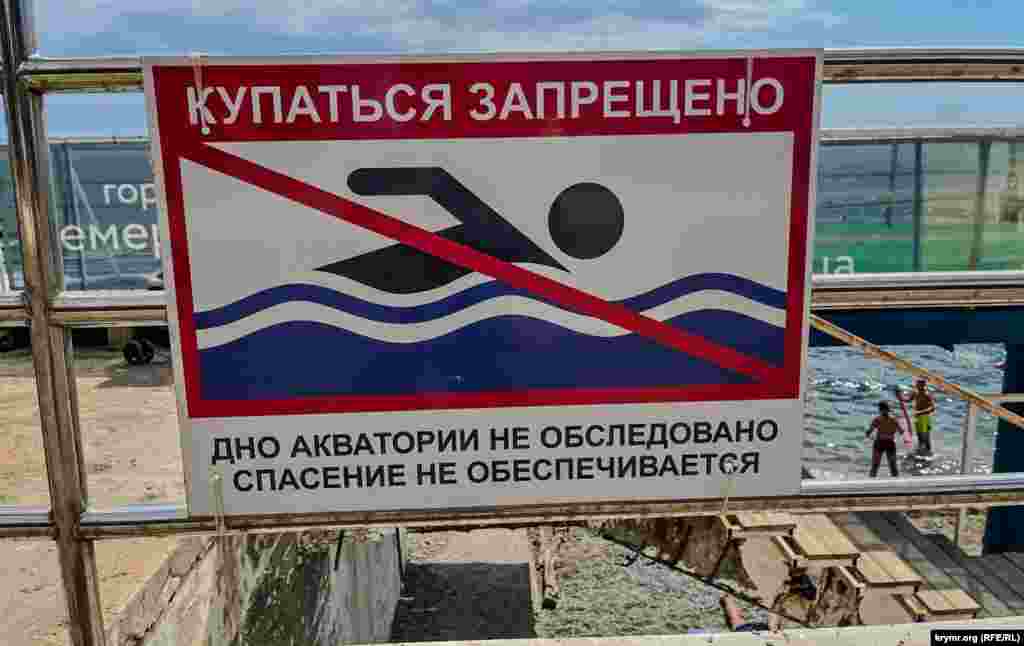 A sign warns swimmers that rescue services are not provided. 