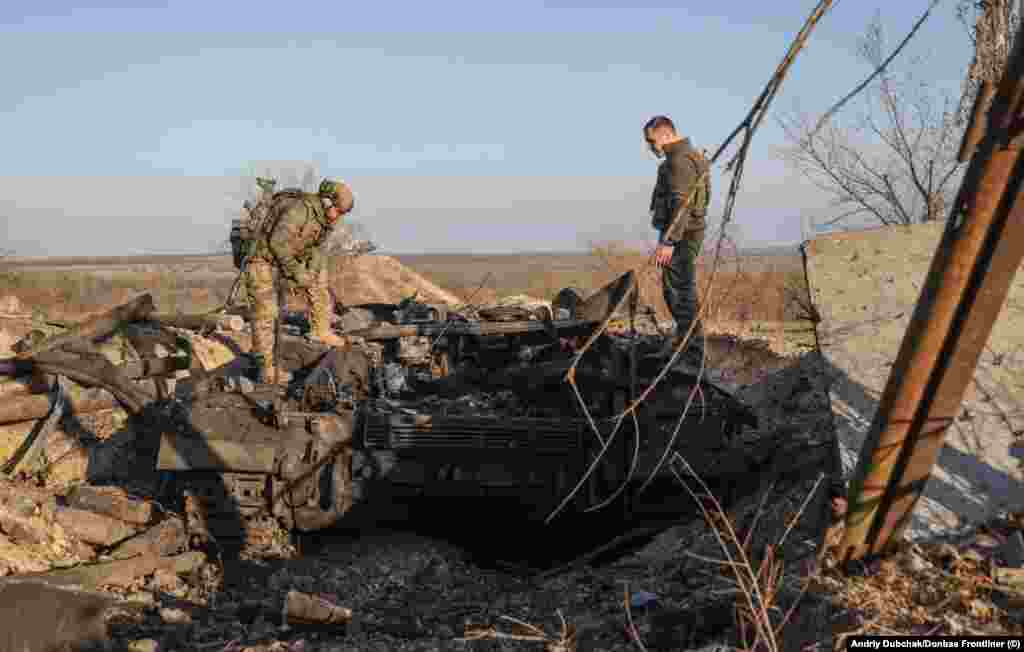Ukrainian troops examine a destroyed tank. Dubchak says he asked locals whether possible war crimes took place in Snihurivka during its occupation by Russian forces but says, "For now, there is no information." 