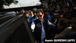 Former Prime Minister Imran Khan (center) leaves the High Court in Islamabad on August 31.