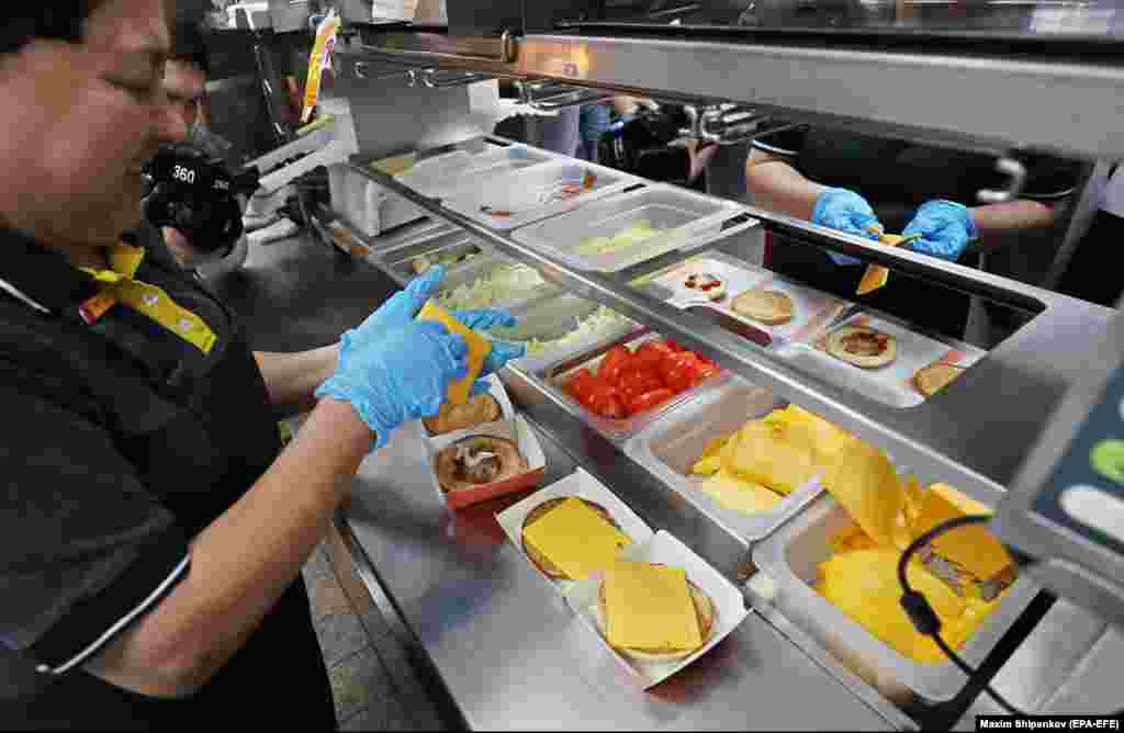 Tasty And That’s It staff construct burgers inside a former McDonald’s in Moscow in June 2022. The renamed fast-food chain got off to a shaky start, with one report of moldy bread being used in a burger in June, but the restaurants appear to be popular.