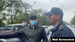 Жол апаты болған жерде тұрған адамдар. "Демпартия" өкілдері масқа таққан адамның жүргізуші Нұрбол Қасымбековке тап бергенін айтты. Ол жоққа шығарды.