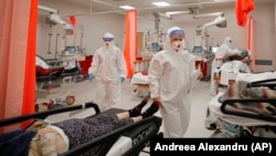 Patients lie on beds in the emergency room, turned into a COVID-19 unit due the high number of cases, at a hospital in Bucharest on October 12.