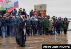 A Russian Orthodox priest conducts a service during a ceremony in memory of Russian soldiers killed in Russia's war against Ukraine.
