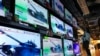 A woman in Hong Kong stands in front of TV screens showing the news that Russian troops invaded Ukraine on February 24.