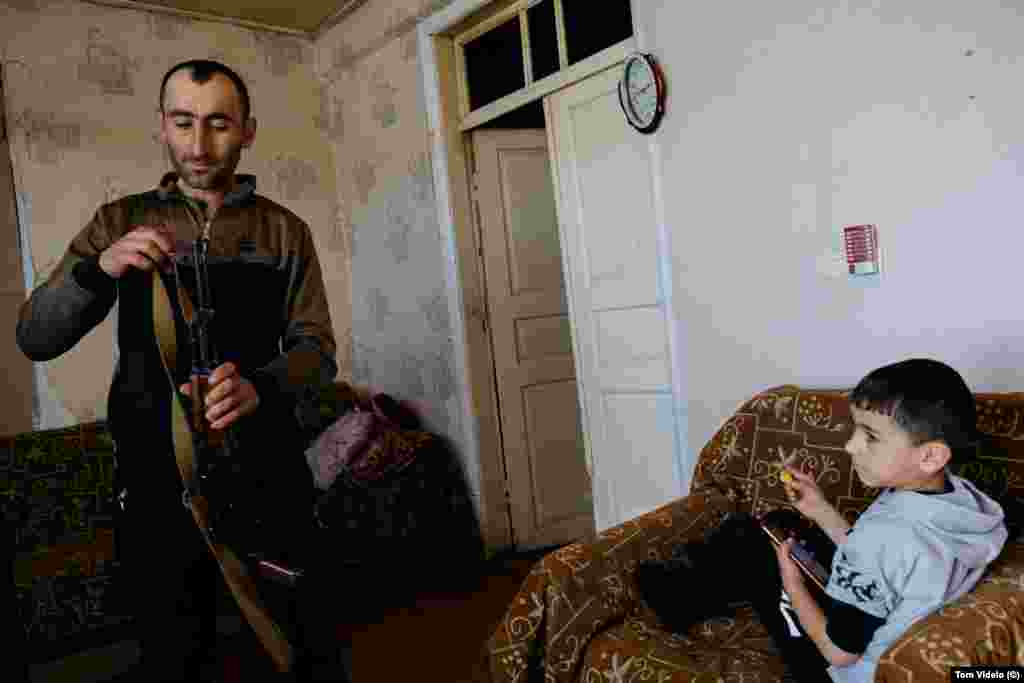 Ruben Balian and his son Garnik in their house in Kornidzor, a village near the blockaded road connecting Armenia with Nagorno-Karabakh. Balian is a member of Armenia’s territorial defense organization and keeps an AK-47 rifle at home. Many fear another breakout of all-out war could be possible amid the ongoing tensions over Nagorno-Karabakh.