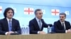 Georgian Dream Prime Minister Irakli Kobakhidze, honorary chairman Bidzina Ivanishvili, and freshly minted presidential candidate lawmaker Mikheil Kavelashvili (left to right) attend the party nomination event on November 26.