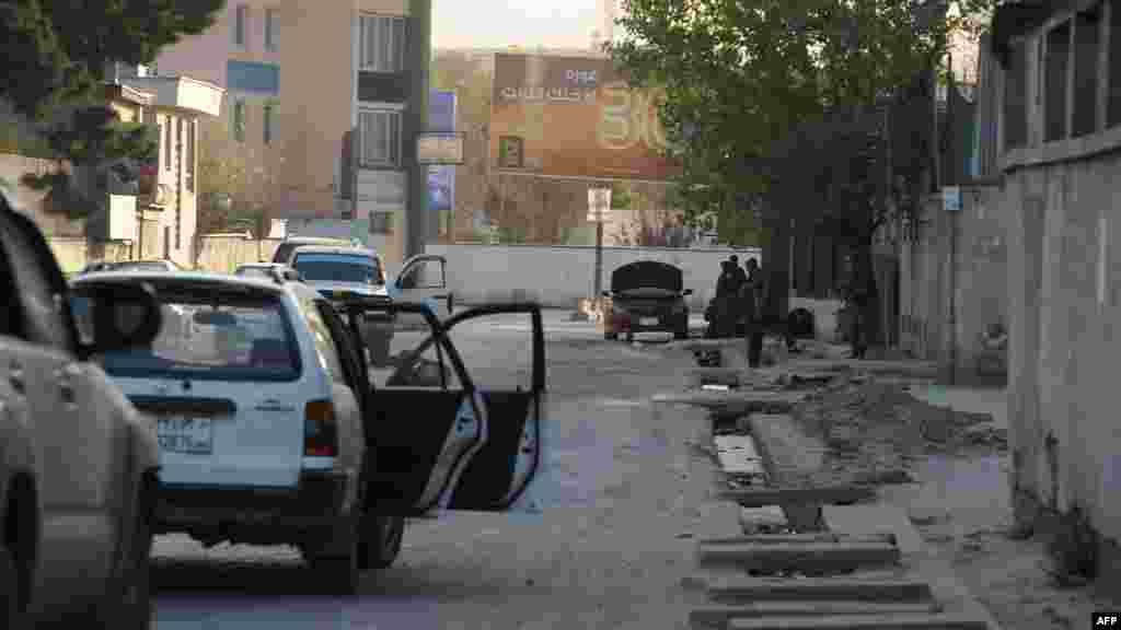 Afghan police take cover near a Kabul building targeted in the coordinated attacks by militants. (AFP/Shah Marai)