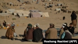 Afghan men sit at a camp for internally displaced persons in Qala-i-Naw, Badghis Province, in October.
