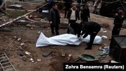Cadavre ale civililor exhumate de poliție în localitatea Buzova, regiunea Kiev, 10 aprilie 2022.