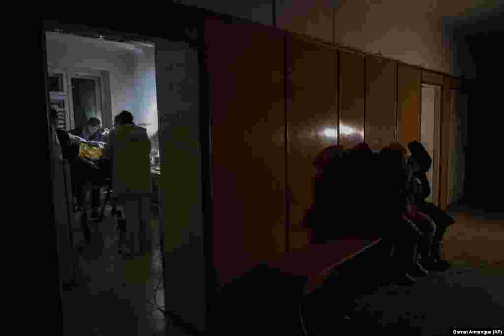 Natalya and her daughter wait in the hospital corridor as doctors stabilize her son, Artur. 