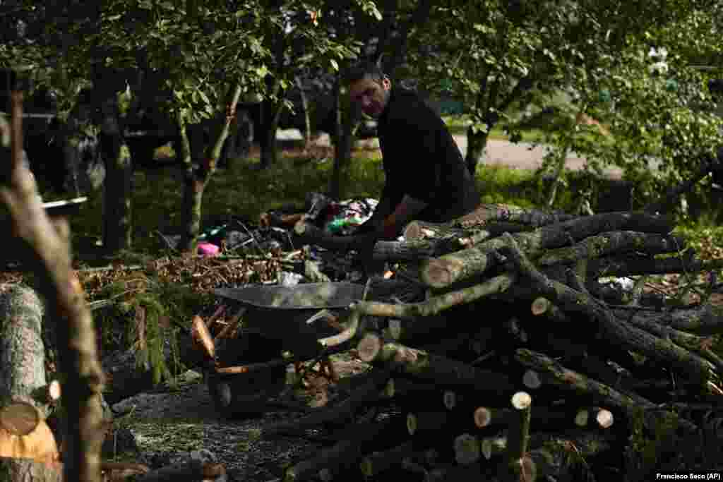 In the nearby village of Kyrylivka, Viktor Palyanitsa piles freshly cut logs in the yard of his house. Palyanitsa, 37, says he's gathered enough wood to last the entire winter. Still, he plans to begin sleeping beside a wood-burning stove in an outbuilding, since all of the windows in his house have been blown out by flying shrapnel. 