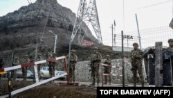 Azerbaijani troops stand guard at a checkpoint at the Lachin Corridor in December 2022.