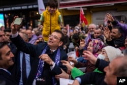 Stambulyň häkimi we Halk-respublikan partiýasynyň dalaşgäri Ekrem Ymamoglu saýlawlardan ozalky duşuşykda öz tarapdarlary bilen surata düşýär. Stambul, 21-nji mart, 2024.