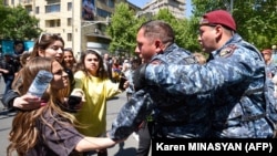 Police officers are seen detaining protesters attempting to block streets in Yerevan on May 17.