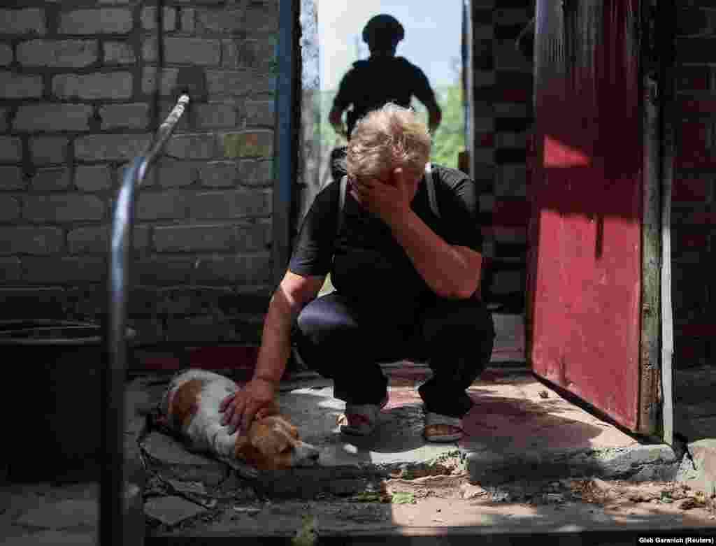 A woman weeps as she strokes her dog, named Hera, who was seriously injured in the Russian attack on Kostyantynivka on July 9.