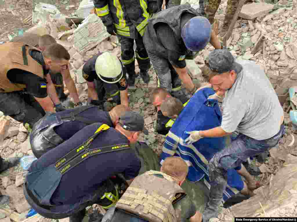 Rescuers retrieve a body from the wreckage.
