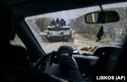 A Ukrainian tank with soldiers is seen through a car window close to the front line near Kremenna in January.
