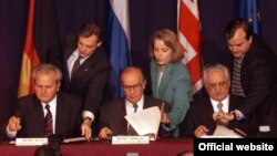 Serbian President Slobodan Milosevic (left), Bosnian President Alija Izetbegovic (center), and Croatian President Franjo Tudjman (right) initial the peace agreement after 21 days of talks at Wright-Patterson Air Force Base in Dayton, Ohio, on November 21, 1995.