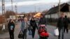 UKRAINE - People walk as they flee from Ukraine to Hungary, after Russia launched a massive military operation against Ukraine, at a border crossing in Tiszabecs, February 27, 2022. 