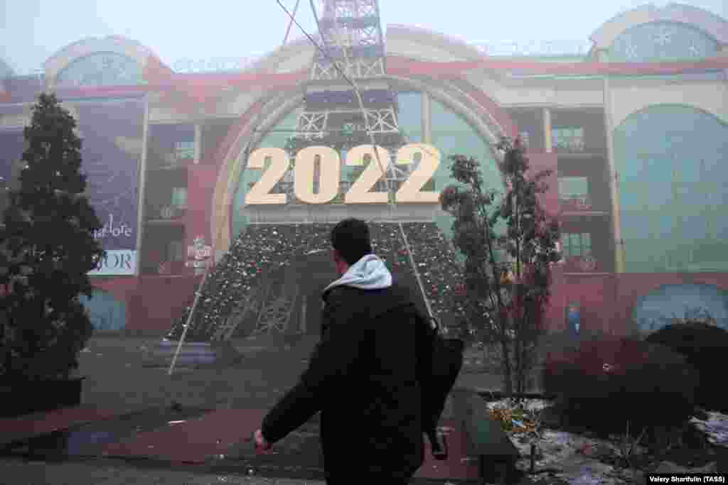 A man walks past the French House perfume store in Almaty on January 6.&nbsp; Security forces in Kazakhstan say they have killed dozens of anti-government rioters in Almaty. The authorities say 12&nbsp;members of the security forces have been killed and 353 injured in the unrest, which was sparked by a doubling in the cost of liquefied petroleum gas (LPG). 