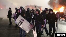 Almatyda protestçilere garşy durýan polisiýa ofiserleri