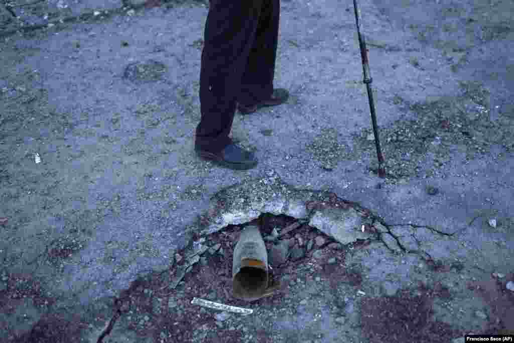 A local man walks past a Russian rocket stuck in the pavement in Kivsharivka. Palyanitsa is not waiting for government help. He says he doesn't expect heating to be restored anytime soon, but that he feels ready to fend for himself even once winter sets in. "I have arms and legs. So I'm not scared of the cold, because I can find wood and heat the stove," he said. 