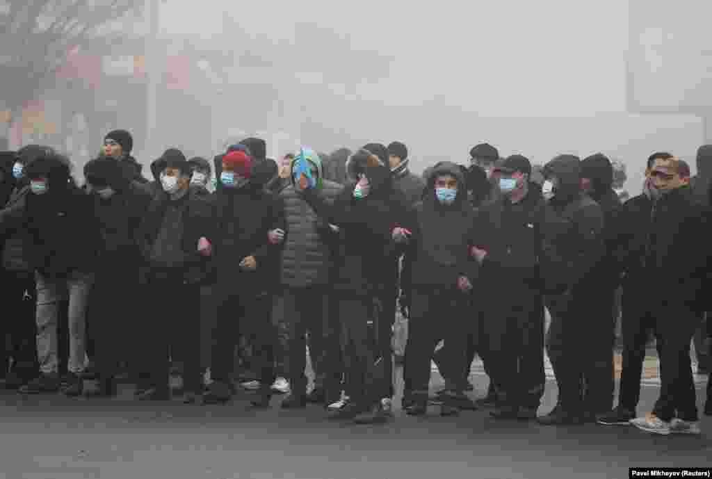 Demonstrators link arms in Almaty on January 5. 