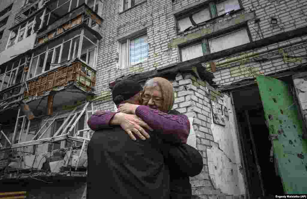 Yevdokia, 65, hugs her son Oleksandr in front of their shelled house in a recently retaken area of Izyum.