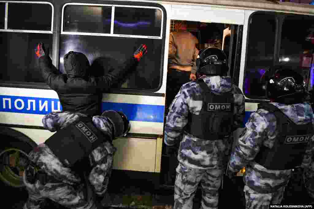 A police officer searches a detainee in downtown Moscow early on February 3.