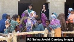 Angelina Jolie (in black) listens through a translator to women in Pakistan's Dadu district on September 20 after they were displaced by historic flooding that has deluged Pakistan since mid-June.