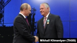 Russian president Vladimir Putin (left) and ExxonMobil Chairman and CEO Rex Tillerson shake hands at an energy summit in St. Petresburg in June 2013.