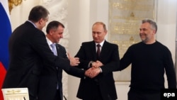 Președintele Vladimir Putin, premierul din Crimeea, Serghei Aksionov, președintele Parlamentului R. Cirmeea, Vladimir Konstantinov și primarul Sevastopolului, Alexei Șali, își strîng mîinile după ceremonia de semnare la Kremlin a legii de atașare la Rusia a celor două entități.