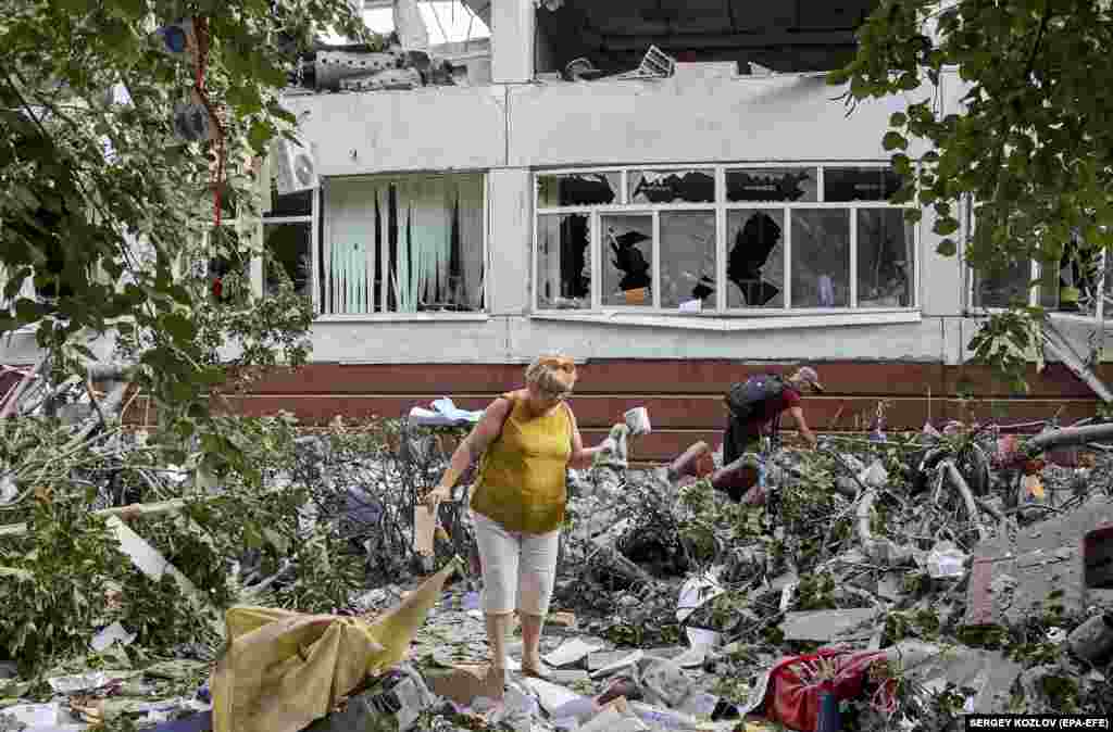 Residents of Kharkiv clean up debris at a damaged school after a Russian missile strike on July 10.