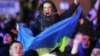 Участница антиправительственной демонстрации с украинским флагом выкрикивает лозунги на Майдане Незалежности в Киеве. 2 декабря 2013 года. 