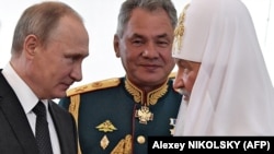 Patriarch Kirill (right) with Russian President Vladimir Putin (left) and Defense Minister Sergei Shoigu. (file photo)