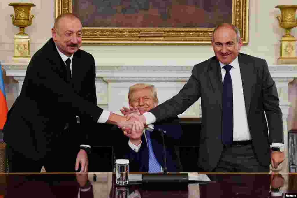 Президент США Дональд Трамп держит за руки президента Азербайджана Ильхама Алиева и премьер-министра Армении Никола Пашиняна во время их рукопожатия во время трехсторонней церемонии подписания в Белом доме в Вашингтоне, округ Колумбия, 8 августа 2025 года. REUTERS/Kevin Lamarque