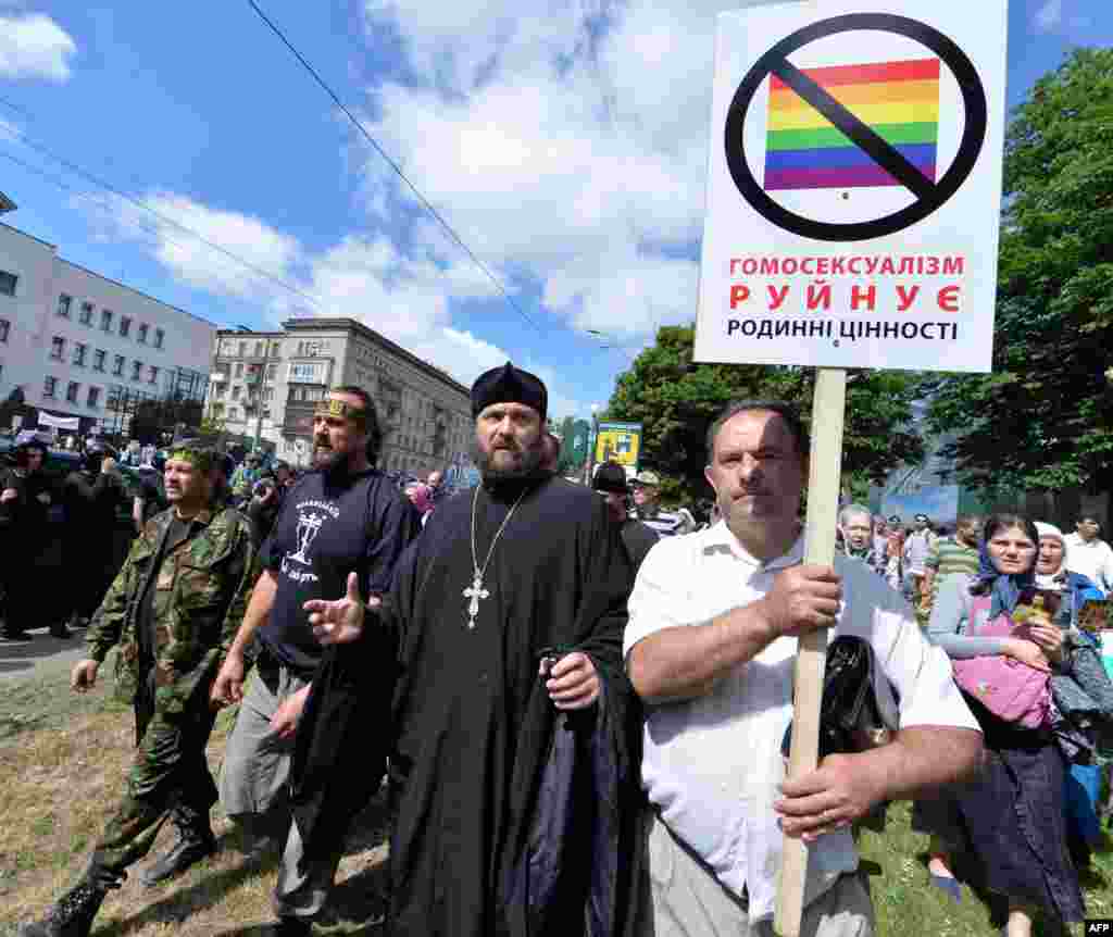 Orthodox believers carry a placard saying "Homosexuality destroys family values" during a counterdemonstration. 