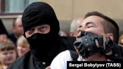 A riot police officer detains a Belarusian opposition supporter during a protest in Minsk on August 30.