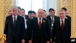 Касым-Жомарт Токаев, Владимир Путин и Шавкат Мирзияев идут на рабочий завтрак лидеров СНГ в Кремль. Москва, 9 мая 2023 года.