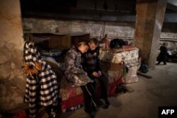 Residents of the Prtrovskyi neighborhood of the city of Donetsk sit in a bomb shelter last November.