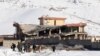 Afghan intelligence officers leave the collapsed building of the military base following an attack in Maidan Wardak on January 21.