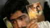 A man in 2007 holds a portrait of Ayatollah Ruhollah Khomeini during a memorial ceremony to mark the 18th anniversary of Khomeini's death at his mausoleum in Tehran.
