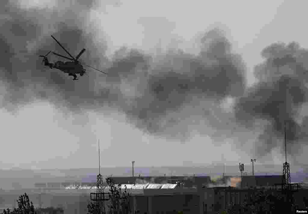 A Ukrainian Mi-24 helicopter gunship fires its cannons at rebels at the main terminal building of Donetsk's international airport on May 26.