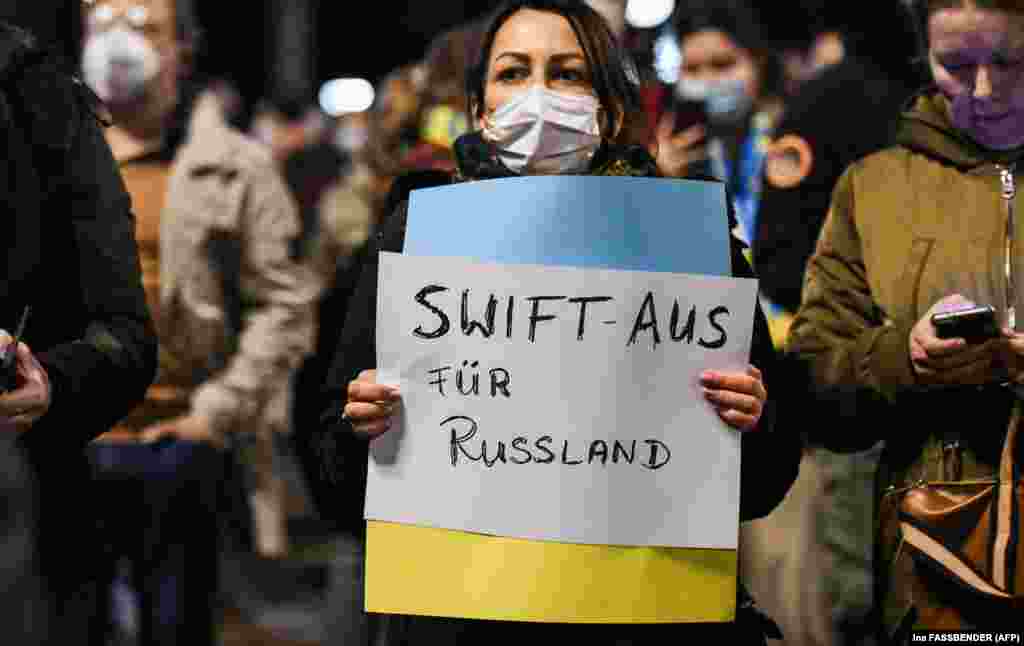 Demonstrators in Berlin demand that Russia be disconnected from the SWIFT financial system on February 25. A group of Western nations led by the United States, the European Union, and the United Kingdom have agreed to block access for &quot;selected&quot; Russian banks to SWIFT.