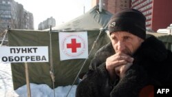 Донецкиде суукта калгандар үчүн тигилген чатырдын жанындагы үйсүз адам, 2-февраль, 2012-ж.