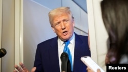 US President Donald Trump speaks to reporters on Air Force One. (file photo)