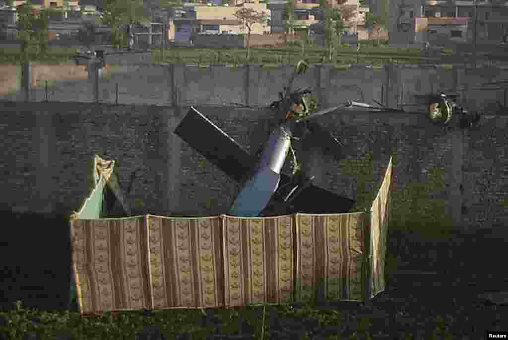 The tail rotor of a destroyed U.S. helicopter at the compound The raid began badly when turbulence created by the compound walls caused one helicopter to lose lift and crash. But the commandos and a trained Belgian Malinois dog forced their way inside the residence and killed bin Laden. The Navy Seals destroyed the downed chopper with explosives before cramming into another helicopter with bin Laden’s body for their escape. 