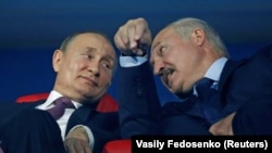 Russian President Vladimir Putin (left) and Belarusian President Alyaksandr Lukashenka speak in the stands during a ceremony in Minsk in June 2019.