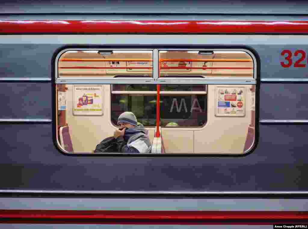 A man covers his face inside the subway. The Czech government has banned most nonessential travel throughout the country. 