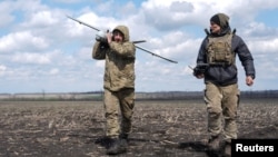 A Ukrainian soldier carries a reconnaissance unmanned aerial vehicle (UAV) before flying over positions of Russian troops near the frontline town of Pokrovsk in the Donetsk region.
